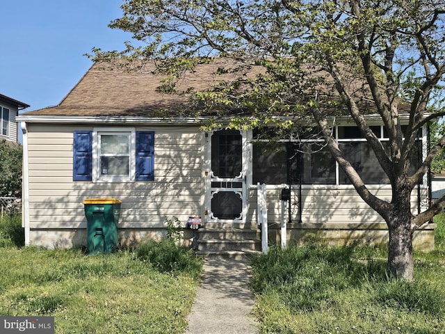 view of front facade featuring entry steps and roof with shingles