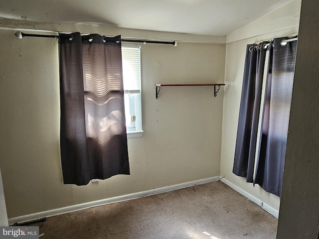 unfurnished room with baseboards and carpet flooring