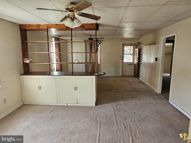 carpeted empty room with baseboards, a paneled ceiling, and ceiling fan