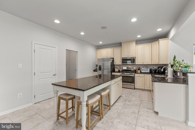 8365 Eagle St, Glen Burnie, MD 21060 - kitchen featuring appliances with stainless steel finishes, cream cabinetry, a sink, recessed lighting, and a center island