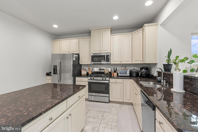 8365 Eagle St, Glen Burnie, MD 21060 - kitchen featuring stainless steel appliances, a sink, cream cabinets, recessed lighting, and dark stone countertops