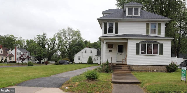 american foursquare style home featuring a front yard