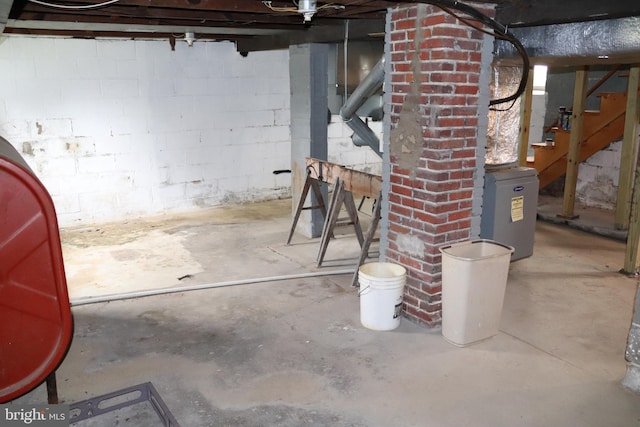 unfinished below grade area featuring stairs and concrete block wall