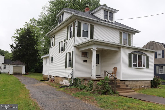 american foursquare style home featuring an outdoor structure, a chimney, and a garage
