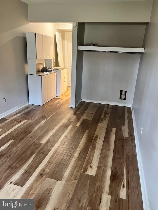 interior space with light countertops, baseboards, and wood finished floors