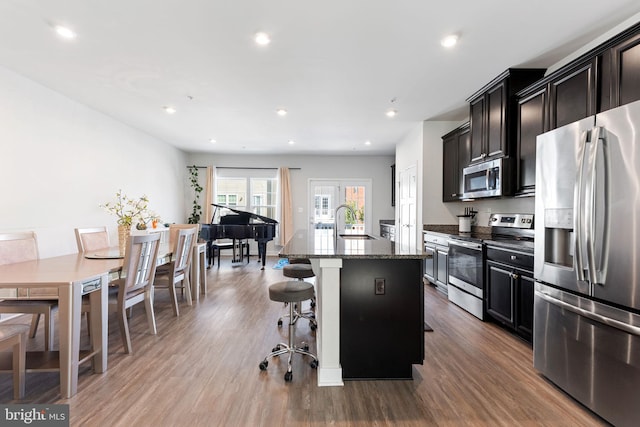 9912 Vista Pointe Dr, Upper Marlboro, MD 20774 - kitchen with a kitchen bar, appliances with stainless steel finishes, a center island with sink, wood finished floors, and a sink