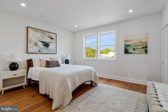 bedroom with recessed lighting, baseboards, and wood finished floors