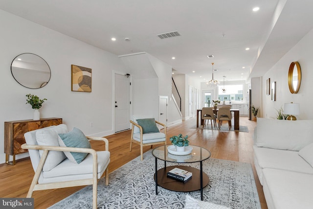 living area with recessed lighting, baseboards, light wood-type flooring, and visible vents