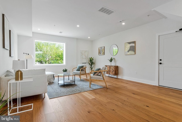 living area with recessed lighting, baseboards, visible vents, and wood finished floors