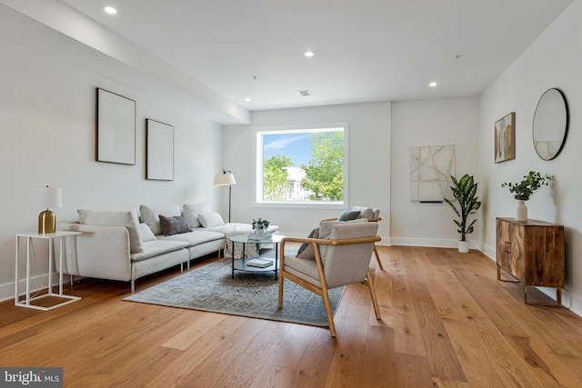 living room with light wood-type flooring, recessed lighting, and baseboards