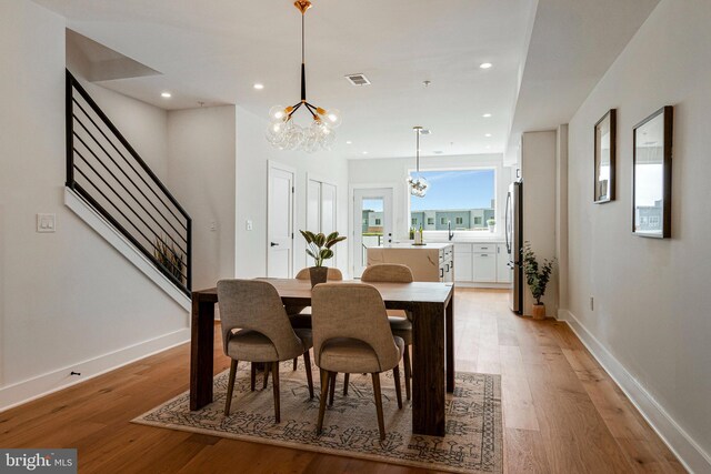 dining space with recessed lighting, a chandelier, light wood-style flooring, and visible vents