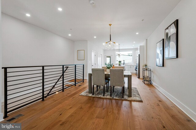 dining room featuring visible vents, baseboards, recessed lighting, light wood-type flooring, and a chandelier