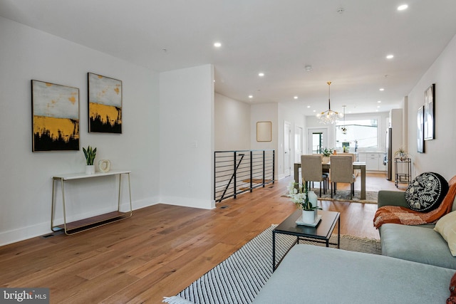 living room with recessed lighting, baseboards, and light wood-style floors