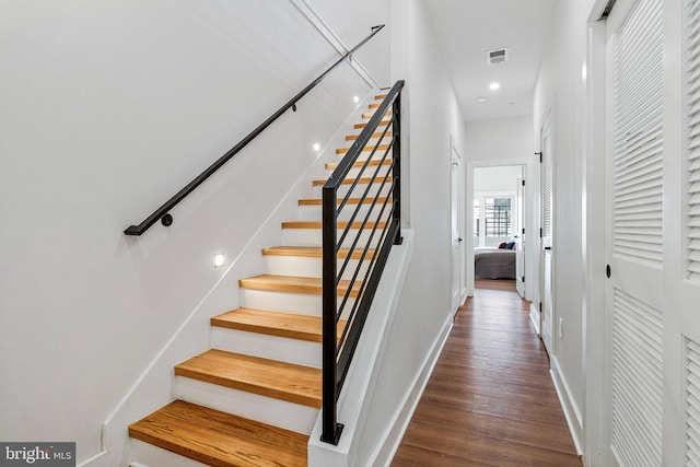 stairway featuring baseboards, recessed lighting, wood finished floors, and visible vents
