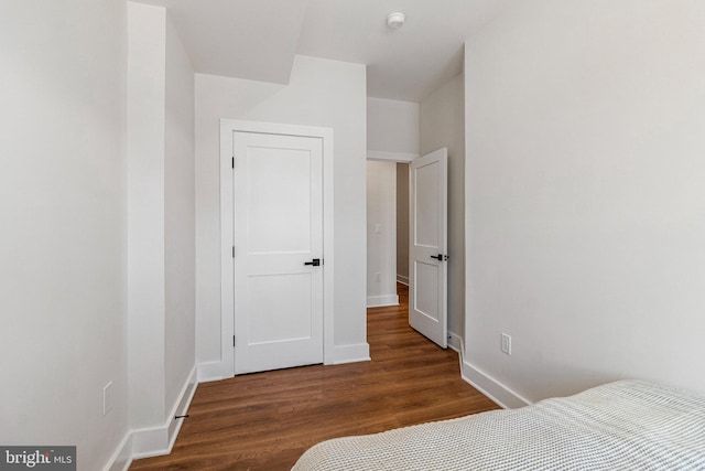 bedroom featuring baseboards and wood finished floors