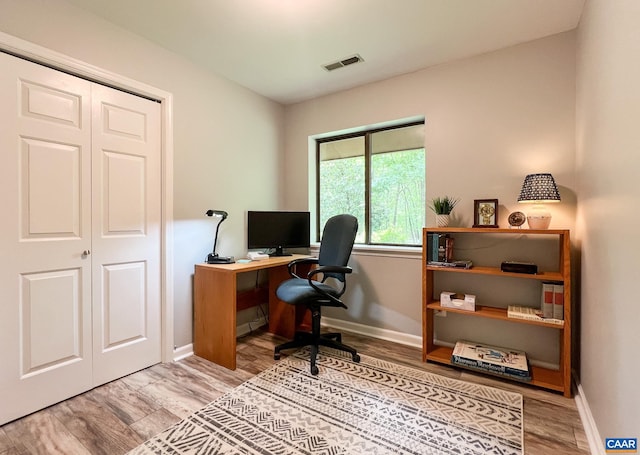 office area featuring visible vents, baseboards, and wood finished floors