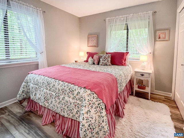 bedroom with baseboards and wood finished floors