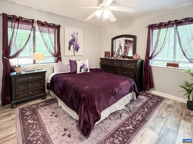 bedroom with light wood-style floors, baseboards, and ceiling fan