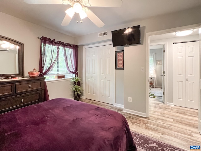 bedroom with light wood-style floors, a ceiling fan, baseboards, visible vents, and a closet