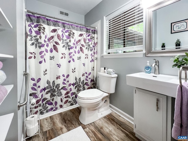 full bathroom featuring visible vents, vanity, wood finished floors, toilet, and baseboards