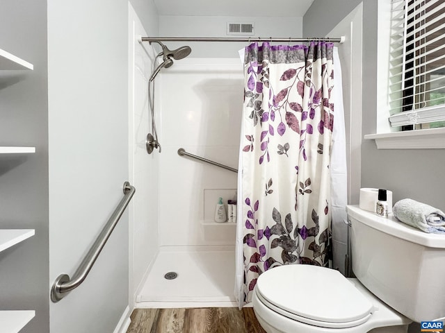 bathroom with visible vents, curtained shower, toilet, and wood finished floors