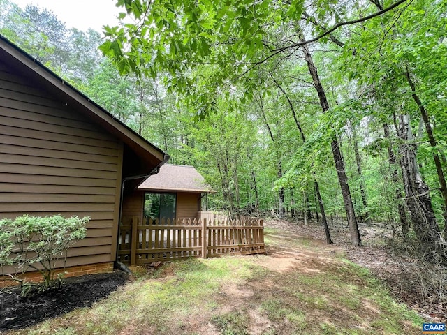 view of yard with a view of trees and fence