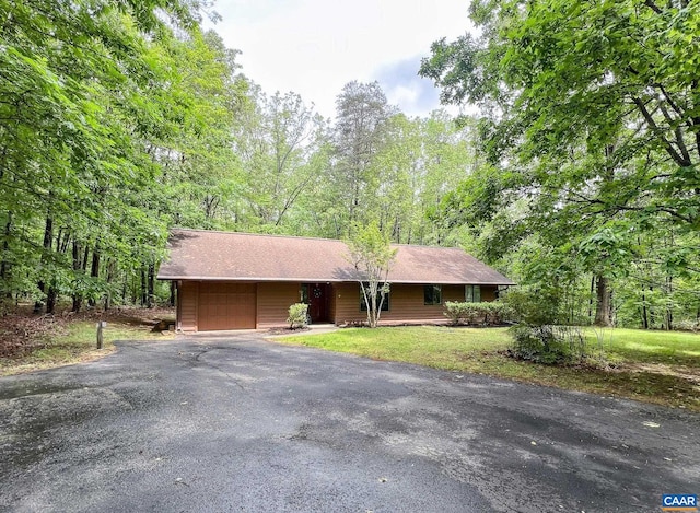 single story home with a garage, roof with shingles, driveway, and a front yard