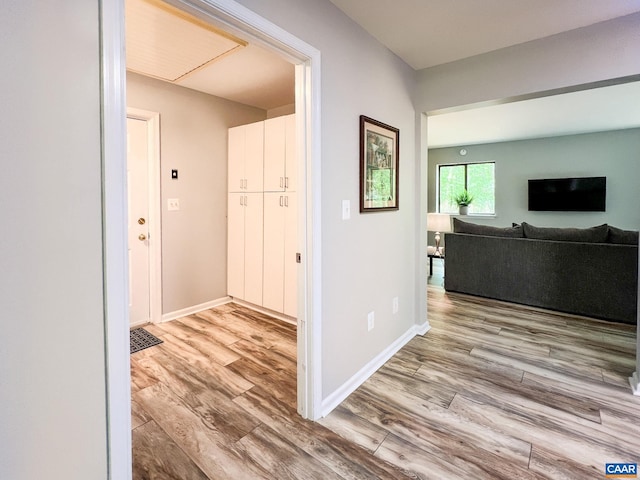 hallway with baseboards and wood finished floors
