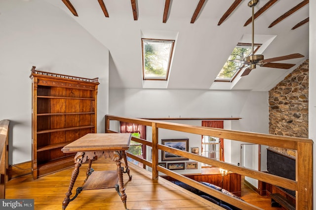 sitting room featuring a skylight, a ceiling fan, hardwood / wood-style floors, and healthy amount of natural light