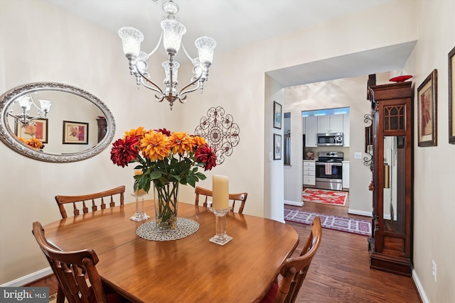dining room featuring a chandelier, dark wood finished floors, and baseboards