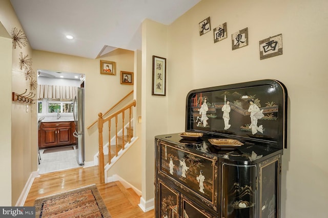 corridor with stairs, recessed lighting, baseboards, and light wood-style flooring