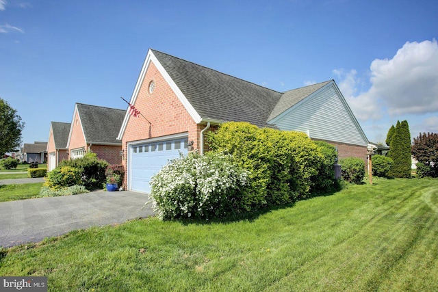 169 Lantern Ln, Chambersburg, PA 17201 - view of side of property with a lawn, brick siding, a shingled roof, an attached garage, and driveway