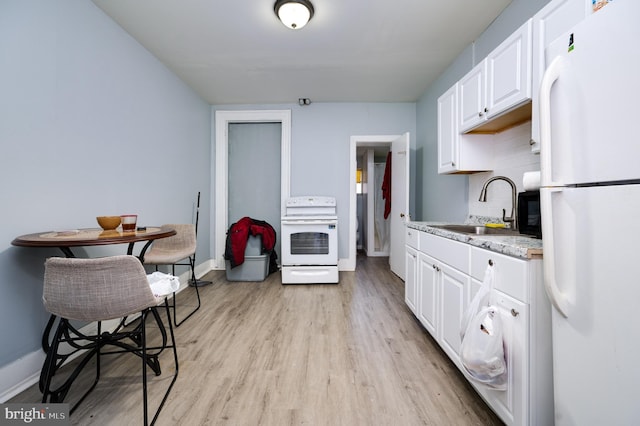 kitchen featuring a sink, white appliances, light wood-type flooring, white cabinets, and baseboards