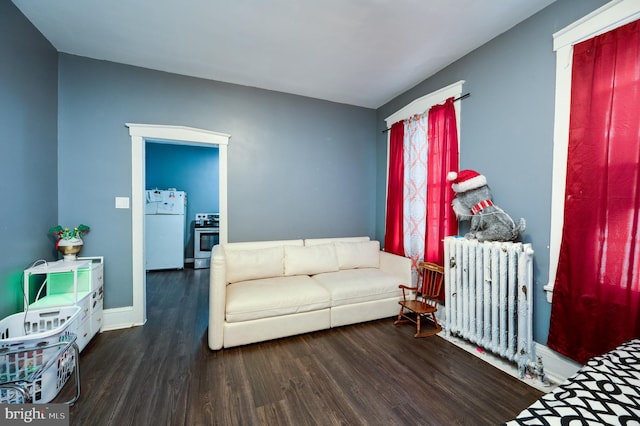 living room featuring radiator, baseboards, and wood finished floors