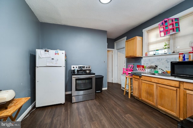 kitchen with a sink, freestanding refrigerator, black microwave, dark wood-style floors, and electric stove