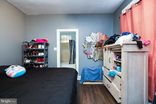 bedroom with dark wood-style flooring