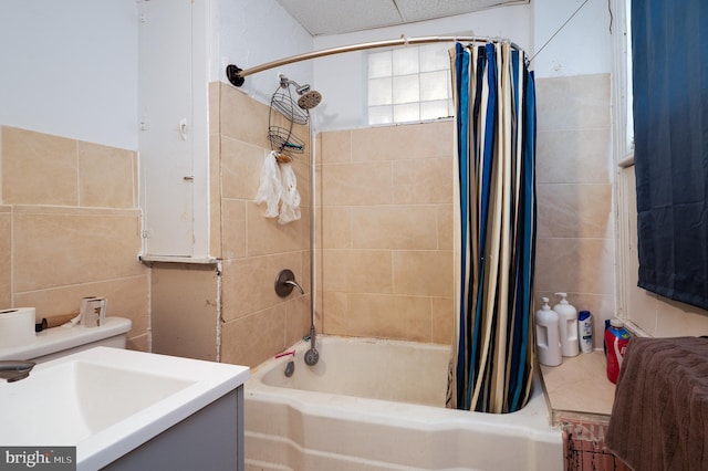full bath with a sink, tile walls, and shower / bath combo