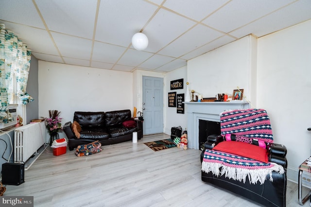 living room with a drop ceiling and wood finished floors