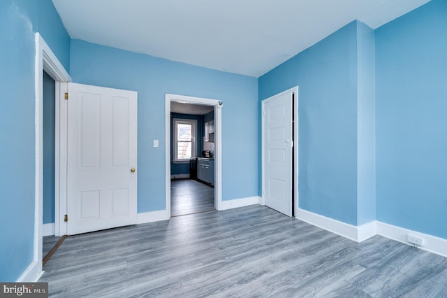 unfurnished bedroom featuring baseboards and wood finished floors