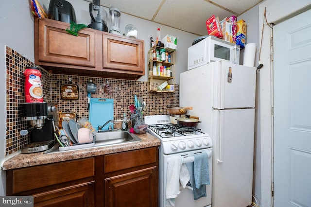 kitchen with brown cabinetry, white appliances, light countertops, and decorative backsplash