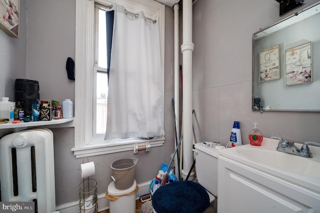 interior space with a wealth of natural light, vanity, and radiator heating unit