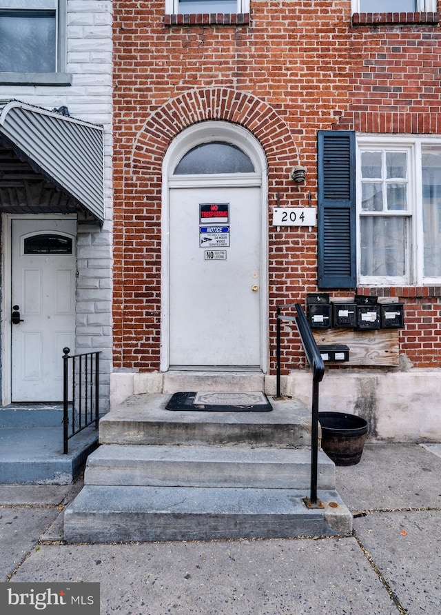 view of exterior entry featuring brick siding