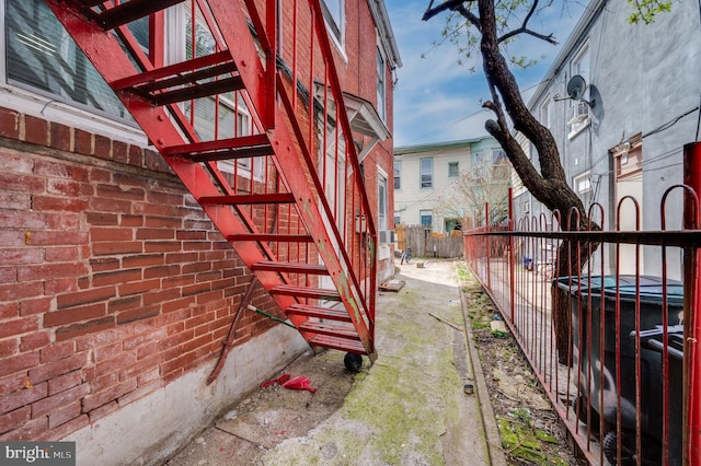 view of side of property with fence and stairs