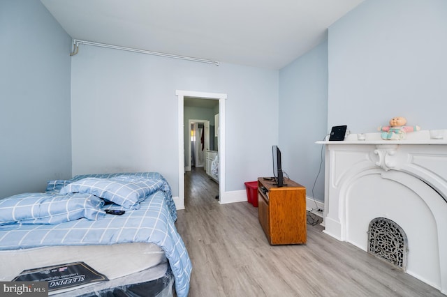 bedroom featuring baseboards and wood finished floors