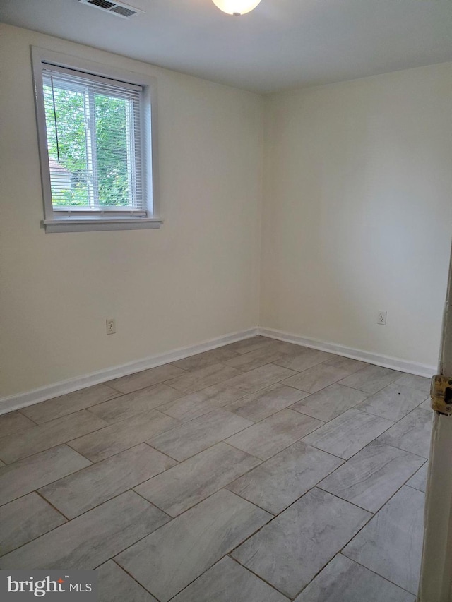 spare room featuring baseboards and visible vents