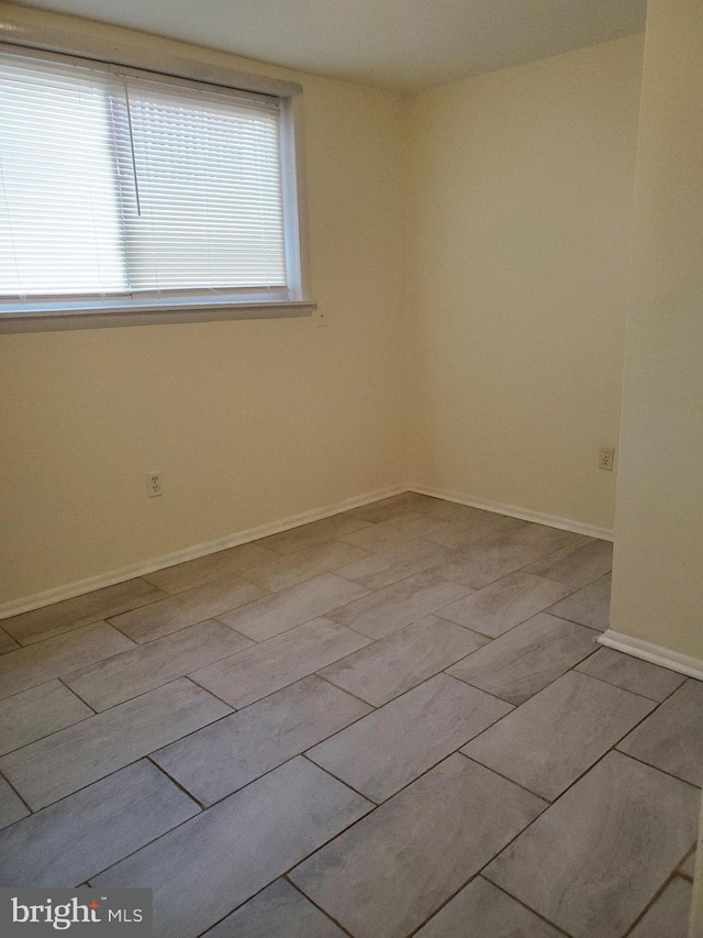 spare room with baseboards