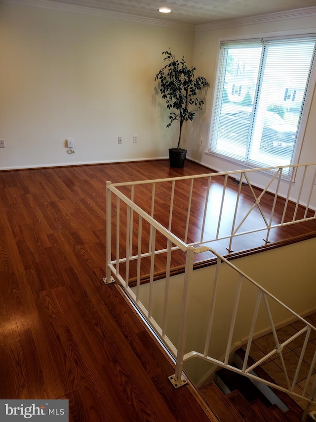 stairs featuring crown molding and wood finished floors