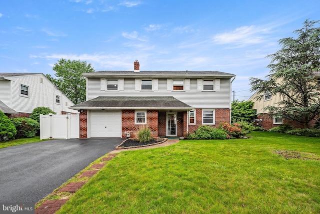 traditional-style house with asphalt driveway, brick siding, a chimney, and an attached garage