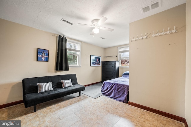 bedroom featuring baseboards, a textured ceiling, and a ceiling fan