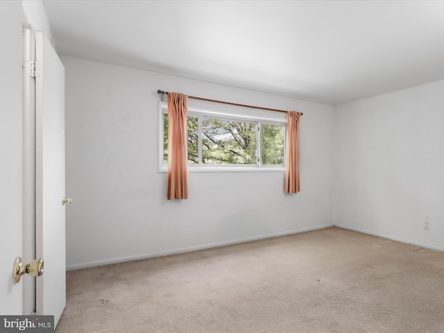 unfurnished room featuring carpet flooring and baseboards
